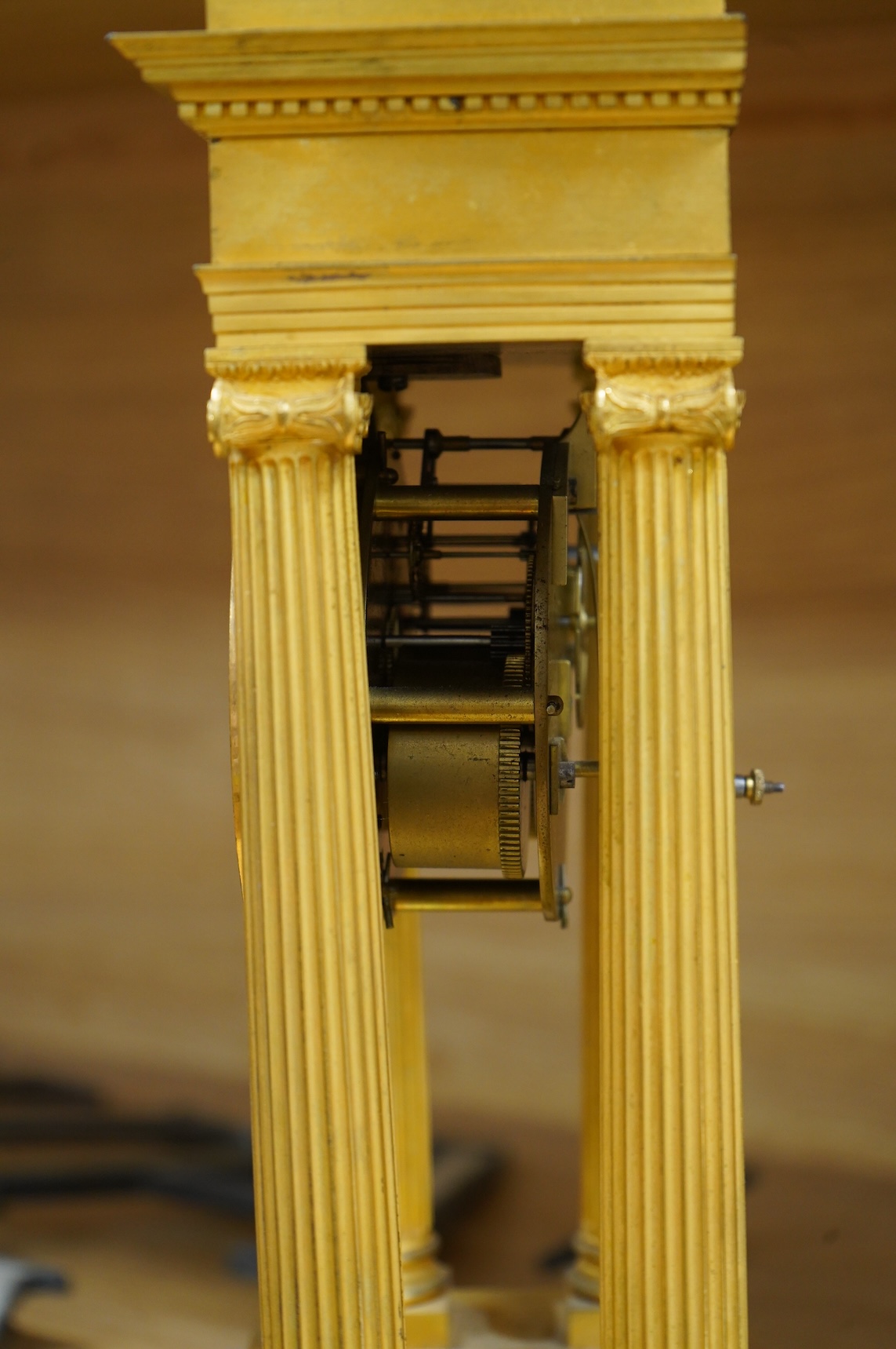 A 19th century French gilt brass eight day portico clock with pendulum, 38cm